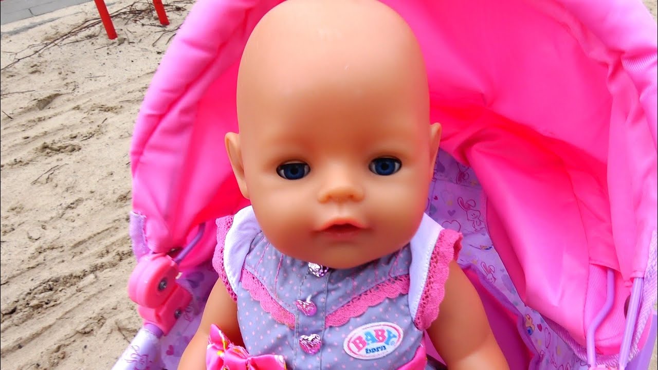 Baby born doll playing with sand molds on the playground