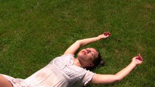 A beautiful young lady embracing nature decides to lay down and relax in the grass