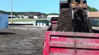 Caterpillar 325C excavator loading trucks in cab view