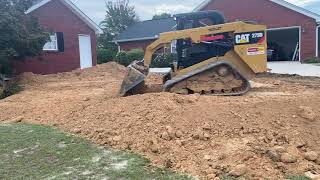 Caterpillar 279d pushing and grading dirt