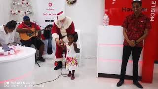 Santa gives a present to a little girl at the opening of Digicel Fiji revamped store at Cumming St.