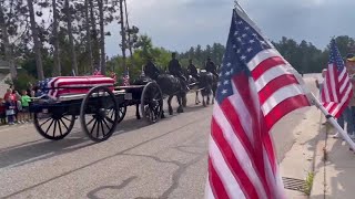 Horse-drawn caisson brings casket for fallen Officer Jake Wallin to funeral in Pequot Lakes, Minn...