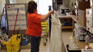 Job coach Betsy Elbert models folding bed sheets at Super 8 Hotel