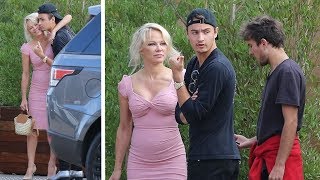 PAMELA ANDERSON, 50, looks youthful in pink dress as she cuddles son BRANDON, 21, during lunch in...