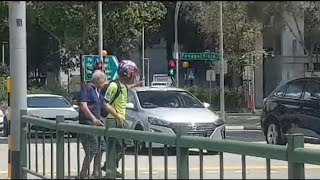 17nov2019 biker helping an elderly with walking disability to cross the road