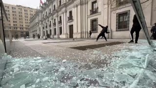 Encapuzados vandalizam parte externa do palácio presidencial durante marcha no Chile | AFP