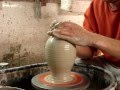 Throwing a clay pottery bottle vase on the potters wheel demo.