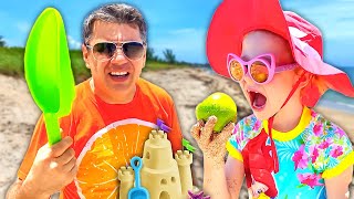 Nastya et papa s'amusent sur la plage et jouent avec des jouets de sable