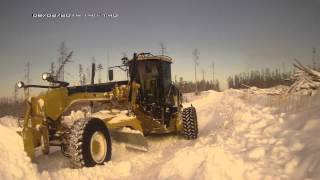 САТ140М AWD чистит снег (The grader cleans САТ140М AWD snow)