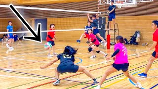 (Volleyball match) She digs the guy's attack with one hand