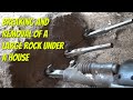 Breaking and removing a large rock from under a house