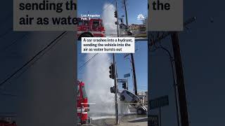 A car crashes into a hydrant, sending the vehicle into the air as water burst out
