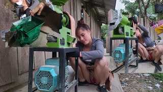 The girl helps people repair a mini rice milling machine for home use using 2-phase electricity.