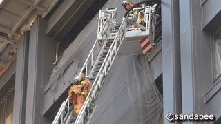 30mはしご車を登る消防士。The firefighter who climbs the ladder of the hook-and-ladder truck by oneself.