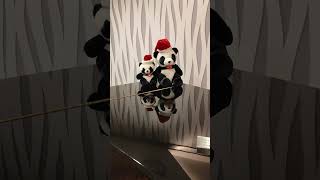 Panda plushie pair in Santa hats on a piano (Vertical)