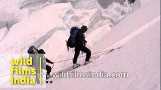 Using a ladder, mountain climbers cross a crevasse in the Ice Fall of Mount Everest