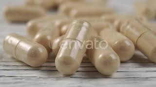 Pile of medical capsules on a wooden surface.