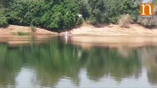 People cross a river of crocodiles to vote