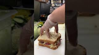 Cutting a sliced bread sandwich for a catering tray