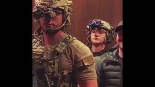 Man being escorted by soldiers in an elevator