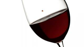 DROPS OF RED WINE BEING DRIPPED INTO A WINE GLASS 4K