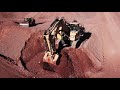 a really big excavator flying over the cat 6040 at tinaja hills