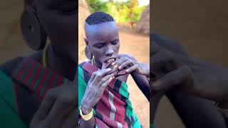 Woman from the Mursi tribe inserts her lip plate, Omo Valley Ethiopia #shorts #ethiopia #omoadvisor