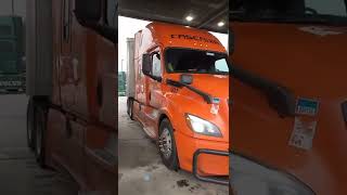 Beautiful orange Freightliner Cascadia  rig Name in front of cab visor lights with black grill bar