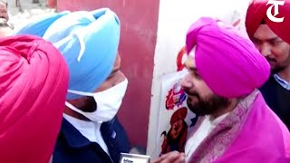 Navjot Sidhu and Bikram Majithia react after coming face to face at polling booth