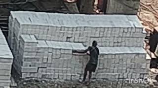 Workers unloading concrete bricks and placing them in formation