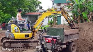 Komatsu MR30 excavator scooping sand onto a tricycle