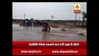 People cross flooded bridge in Damoh village of MP