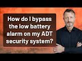 How do I bypass the low battery alarm on my ADT security system?