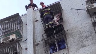 Firefighters save girl hanging from window