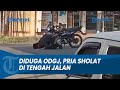 AKSI SEORANG PRIA LAKSANAKAN SHOLAT DI TENGAH JALAN DI PRAPATAN LAMPU MERAH