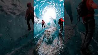 Group of People Walk Through Mesmerizing Blue Ice Tunnel