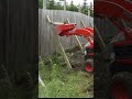 Kubota BX tractor installing fence support strut