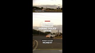 A police chase ends with a car going airborne over a roundabout