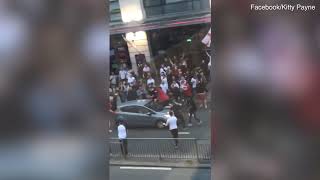 Over excited England fans clamber over moving cars as they pour out of pubs