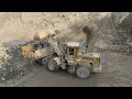 incredible power show by old wheel loader caterpillar 966e performing difficult task of rock loading