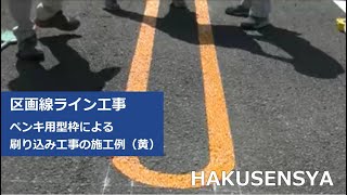 駐車場に型枠を使って黄色のペンキで区画線ラインを書く