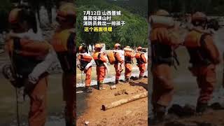 暴雨過後消防員抱孩子排隊過河