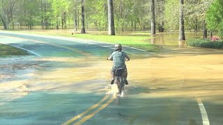kids ride dirtbikes through our flooded neighborhood. Too much rain for the river