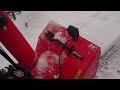 ariens snowblower with wet heavy snow on gravel driveway.