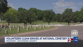 Volunteers clean graves at National Cemetery