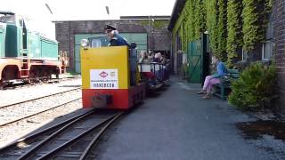 Schöma-Feldbahnlok 2405/1960 verlässt mit einem Besucherzug die Lokhallen Richtung Besuchereingang.