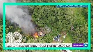 Firefighters working to put out a house fire in Pasco County