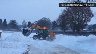 Digger clearing Norfolk road gets caught in snow drift