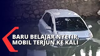 Diduga Pengemudi Baru Belajar Menyetir, Sebuah Sedan Tabrak Trotoar dan Terjun ke Kali