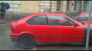 2 students in BMW e36 Compacts performing little burnout next to their school.